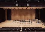 Interior del auditorio con escenario y butacas dispuestas para evento