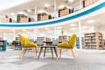 Interior de la biblioteca moderna con zona de lectura y estanterías