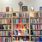 Interior de la librería con estanterías llenas de libros y decoración acogedora