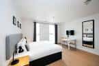 Habitación moderna con cama doble, escritorio y decoración minimalista