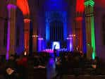 Concierto o presentación en el interior de la iglesia con iluminación multicolor y público sentado