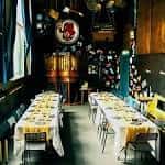 Sala preparada para eventos con mesas cubiertas y decoración temática