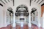 Interior del salón principal con bóvedas de ladrillo y vigas de madera oscura