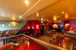 Interior del pub The Reliance con barra de madera y zona de estar