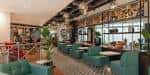 Interior del restaurante Wilderness con decoración moderna y sofás verdes