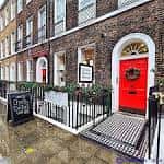 Fachada del Museo Charles Dickens con puerta roja y decoración navideña