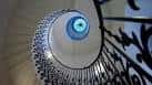 Detalle arquitectónico de una escalera espiral interior con barandilla ornamentada