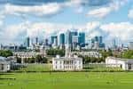 Panorámica amplia del Queen's House rodeado de jardines y rascacielos urbanos