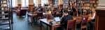 Sala de lectura con personas trabajando en escritorios