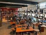 Amplia sala del museo mostrando múltiples máquinas de coser antiguas organizadas en filas