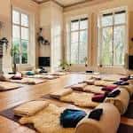 Sala de meditación con cojines y mantas dispuestos en el suelo