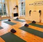 Sala de yoga preparada con esterillas verdes y bloques de apoyo