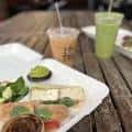 Comida y bebidas sobre una mesa de madera al aire libre