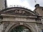 Detalle arquitectónico del frontón con calaveras sobre el arco de entrada principal