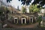 Estructura circular de mausoleos con fachadas arqueadas rodeada de árboles