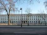 Vista exterior de Wellington Barracks con fachada clásica y árboles sin hojas
