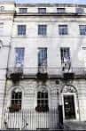 Fachada exterior del edificio con ventanas simétricas y balcones ornamentados