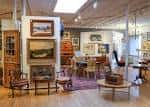 Interior de la galería con obras de arte expuestas y mobiliario