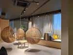 Interior moderno de Hygge con sillas colgantes y zona de estar junto a ventana