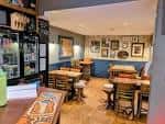 Interior del pub con mesas y decoración típica de pub británico