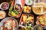 Platos de meze y tapas griegas servidos en una mesa, mostrando variedad de alimentos frescos