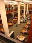 Interior del atrio principal del Hillman Library con mesas de estudio y columnas blancas