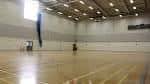 Gimnasio interior con suelo de madera y canastas de baloncesto