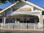 Fachada exterior del Global Gallery Coffee Shop con porche blanco