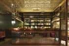 Interior del bar con estanterías de botellas y barra de madera