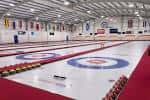 Vista interior de las pistas de curling con anillos y piedras en el hielo