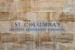 Detalle del nombre de la iglesia grabado en la pared de piedra