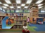 Zona infantil de la biblioteca con juguetes educativos y alfombras coloridas