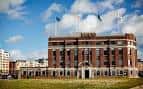 Vista exterior completa del complejo The Tetley con banderas y entorno urbano