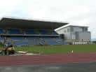 Vista exterior del estadio con gradas azules y pista de atletismo