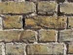 Detalle de una pared de ladrillo antiguo tipo London Stock con tonos amarillentos y mortero desgastado