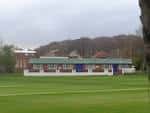Vista exterior del Kirkstall Educational Cricket Club con el edificio principal y campo de juego
