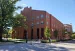 Vista exterior de la Biblioteca de la Avenida 18 en Columbus, edificio de ladrillo rojo con árboles alrededor