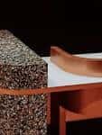Detalle arquitectónico de una mesa con superficie texturizada y estructura metálica