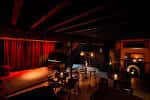 Interior del club SJQ con escenario y cortinas rojas