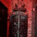 Entrada principal del local con puerta de hierro forjado y detalles góticos