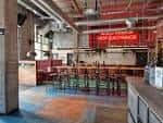 Interior del bar BrewDog con barra de madera y decoración industrial