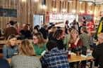 Interior del taproom de Redwell Brewing con clientes sentados en mesas largas