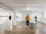 Interior de una galería de arte con exposiciones y visitantes