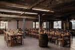 Sala de eventos preparada con mesas y sillas dispuestas para recepción