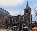 Fachada frontal de la iglesia con puestos de mercado o eventos al aire libre en la plaza delantera