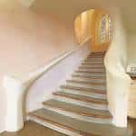 Escalera interior con barandilla curva y paredes de tonos cálidos