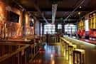 Interior del bar con barra larga y ambiente industrial