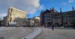 Vista panorámica de Bristo Square con edificios históricos y modernos bajo un cielo parcialmente nublado