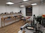 Interior del espacio de electrónica con mesas de trabajo y equipos organizados