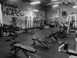 Vista en blanco y negro del interior del gimnasio con equipamiento deportivo